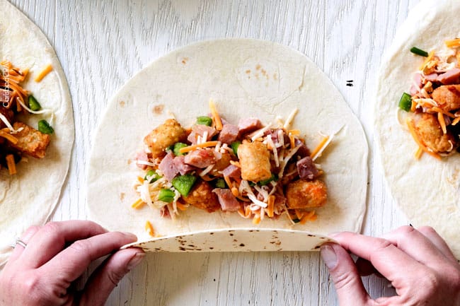 showing how tot make breakfast enchiladas by folding tortillas up with filling