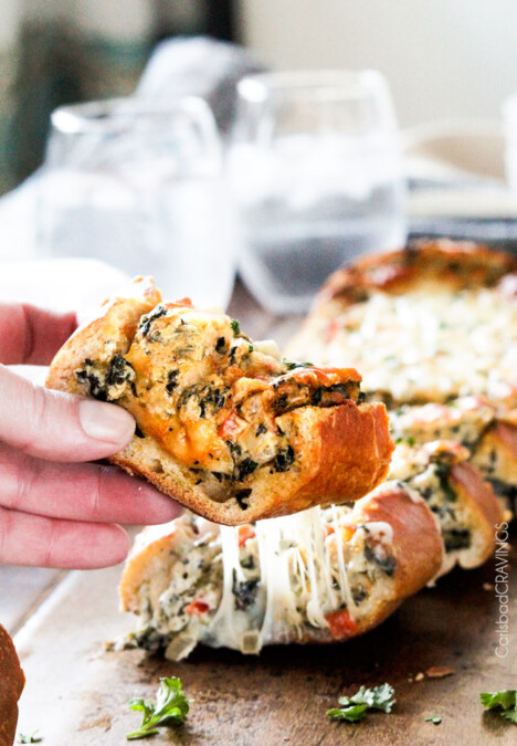 Easy Spinach Dip Stuffed French Bread is your favorite cheesy dip baked right into the loaf! Crazy delicious side or easy crowd pleasing appetizer!