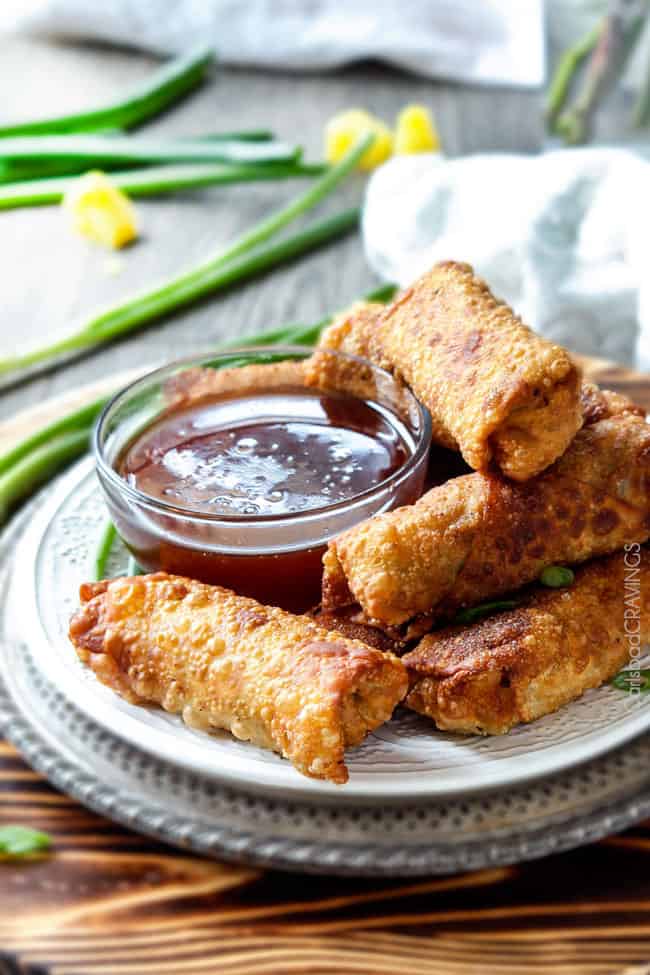 Sweet and Sour Chicken Egg are the best egg rolls I’ve ever had with the best sweet and sour sauce! And made extra fast with the food processor. I am bringing these to all my holiday parties! #appetizer #NewYears #Christmas a stack of chicken egg rolls on a plate