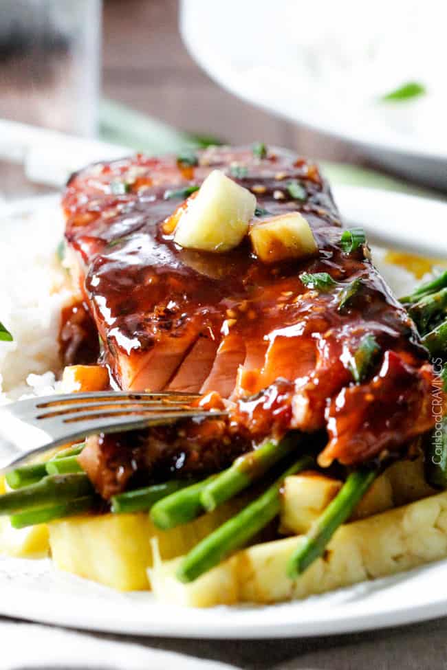 A close up view of Asian BBQ Salmon on a plate with asparagus and rice.