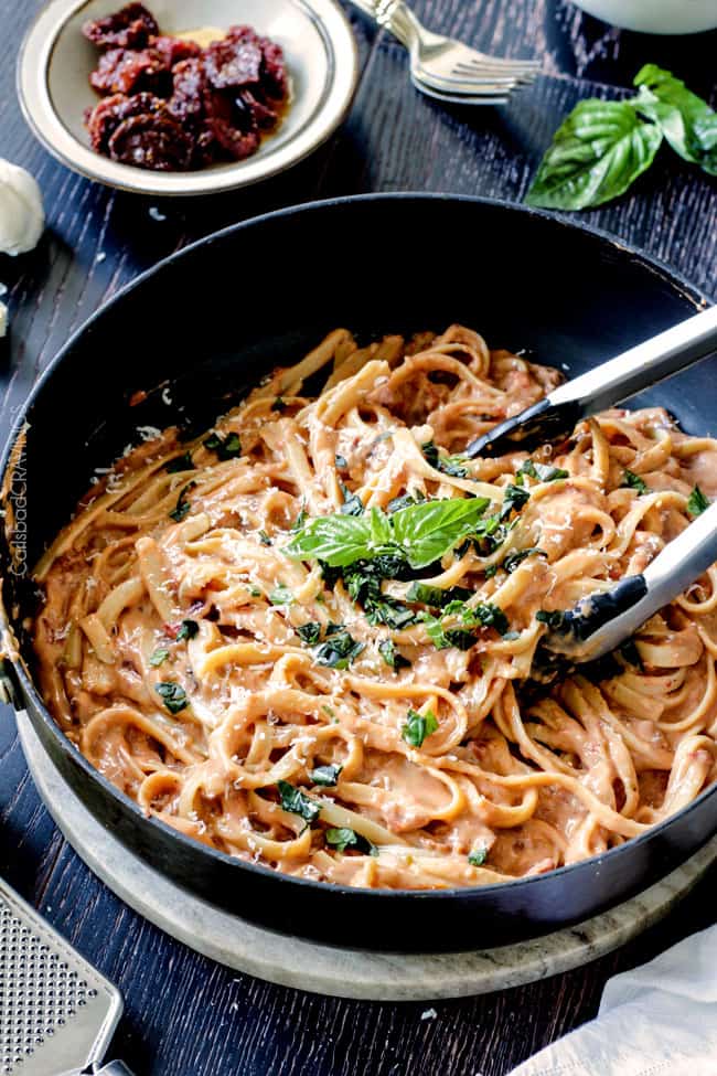 A pan of Sun-dried Tomato Fettuccine Alfredo with basil on top.