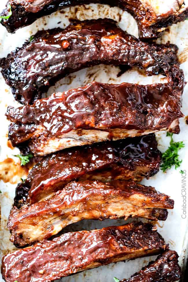 showing how to use BBQ sauce recipe by smothering ribs with homemade BBQ sauce
