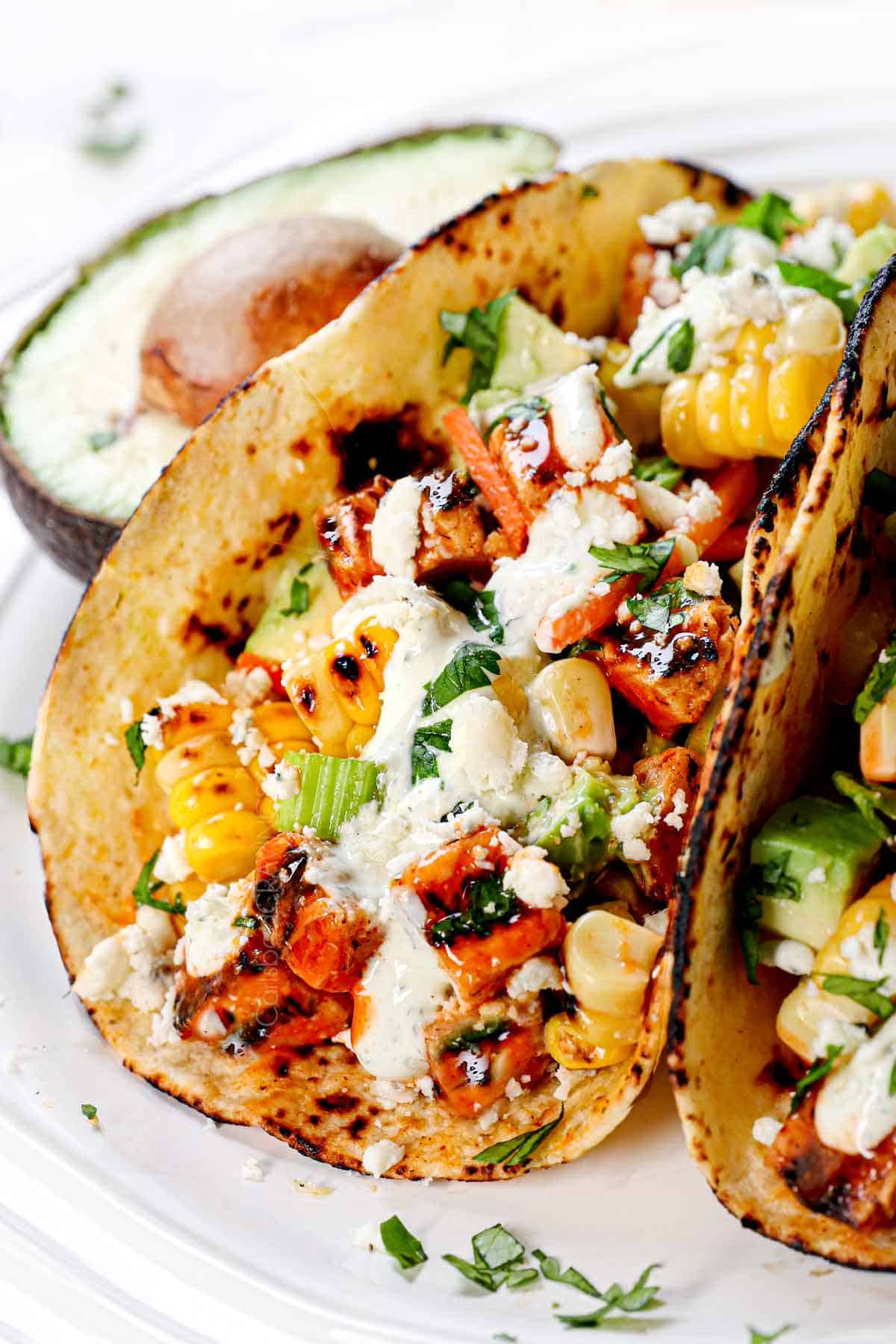 up close of buffalo chicken tacos showing the juicy chicken and fresh, crunchy celery carrot topping