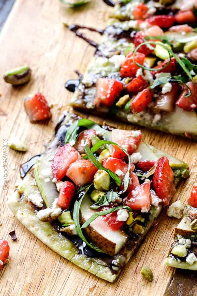 this fresh, sweet and salty Strawberry Pear Pesto Flatbread with Balsamic Reduction Drizzle smothered in brie cheese and garnished with feta and pistachios is OUT OF THIS WORLD! and super easy! Amazing appetizer, brunch or lunch! #Easter #Christmas #holiday