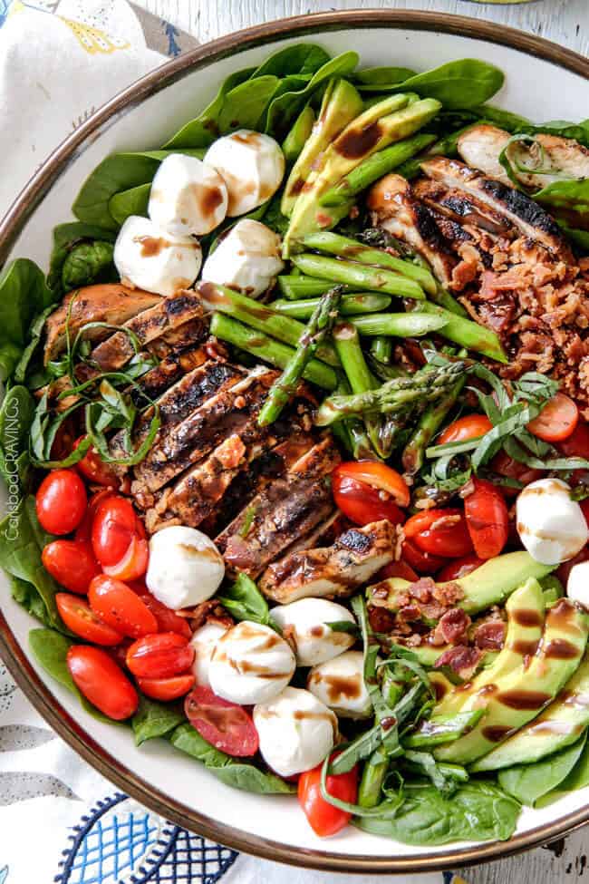 Grilled Caprese Chicken Salad with the most incredible balsamic marinated chicken, fresh tomatoes, creamy mozzarella, grilled asparagus, creamy avocado and crispy bacon all drizzled with Creamy Balsamic Reduction Dressing. Out of this world! #summersalad #springsalad