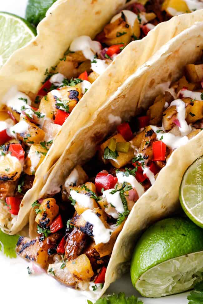 Close up of a Teriyaki Chicken Tacos with Grilled Pineapple Pear Salsa with cream sauce.
