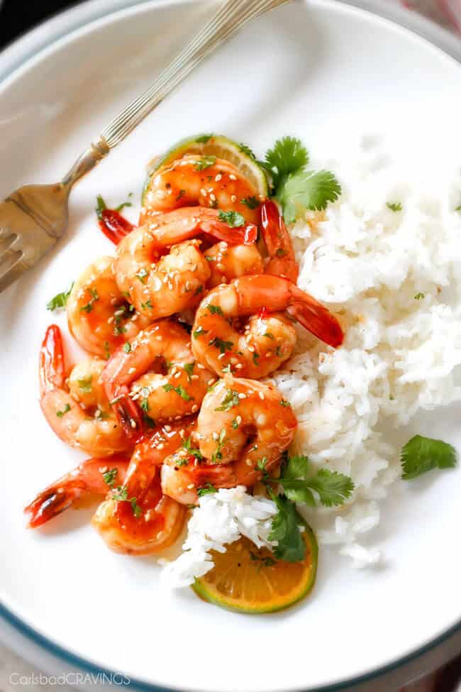 Sweet Chili Shrimp with lime garnish over white rice.