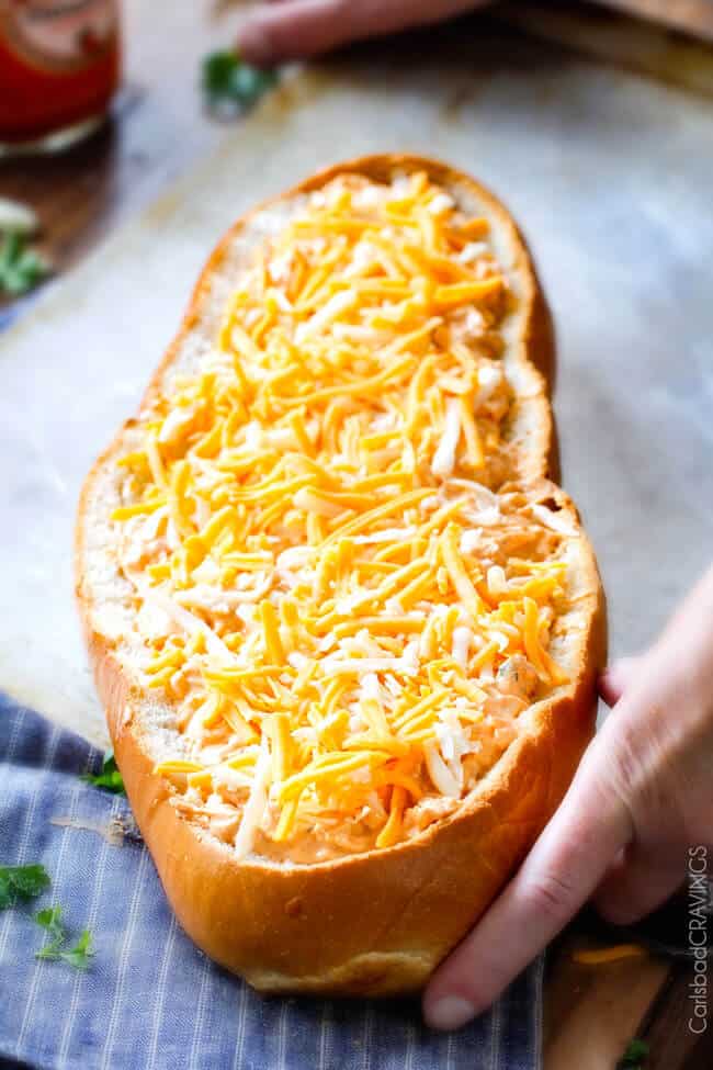 Adding cheese tot he Buffalo Chicken Dip (Stuffed French Bread)