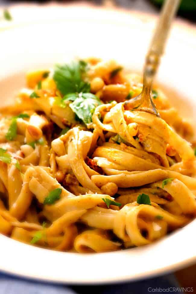 Creamy Butternut Squash Pasta - silky quick and easy pasta that is SO creamy and absolutely addicting! Infused with fresh Parmesan, seasoned to perfection and topped with crispy bacon and toasted pine nuts! #glutenfree #fall up close of a forkful of Creamy Butternut Squash Pasta in a white bowl