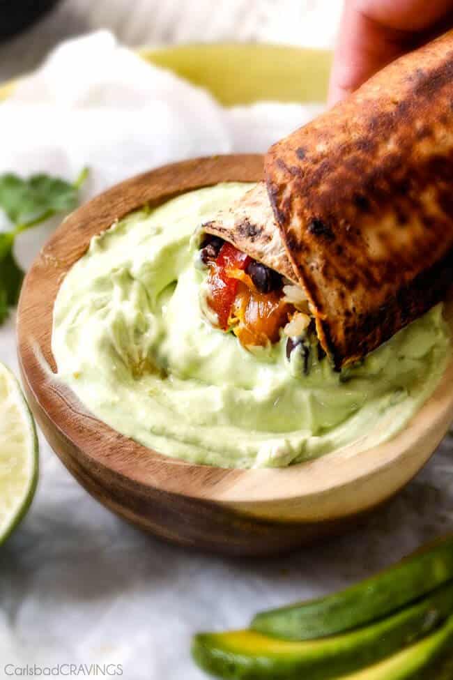 Chicken Fajita Wraps with Creamy Avocado Dip - layers of cheese, black beans, rice, the BEST chicken fajita filling, and sour cream all rolled up then skillet toasted for slightly crispy wraps that are absolutely addicting!! This is our family's favorite way to eat leftover chicken fajita filling!