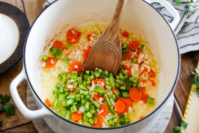 Showing how to make White Chicken Lasagna Soup cooking vegetables in a pot.