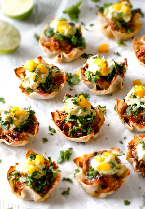 Salsa Verde Honey Lime Chicken Taco Cups - the cheesy sweet heat packed into these crispy, taco cups is so addicting and the mango guacamole is the perfect finishing touch! Whenever I serve these for an appetizer they get gobbled right up!