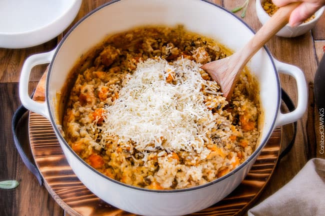 No Babysitting, easy, creamy BAKED Butternut Squash Risotto with Pine Nuts and Pepper Jack! This simple to prepare risotto is wonderfully smooth and creamy, seasoned to perfection and is absolutely fool proof! It makes the most amazing Thanksgiving or holiday side but is easy enough for every day! showing how to make Baked Butternut Squash Risotto by removing the rice from and adding Parmesan