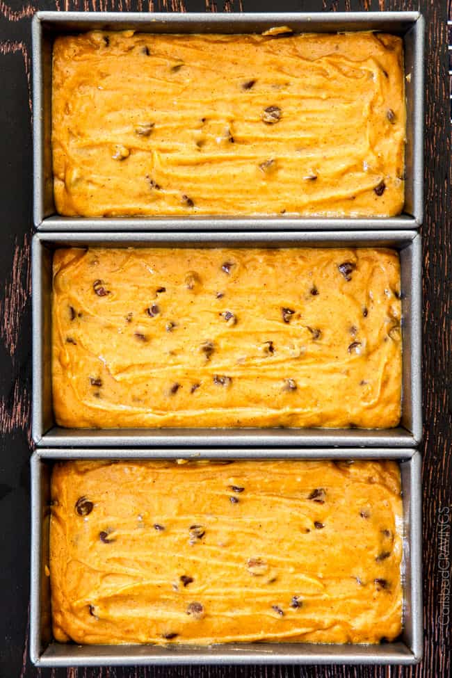 My Mom’s Famous Chocolate Chip Pumpkin Bread! So incredibly moist, infused with cinnamon, cloves and nutmeg with only 2 bowls and one whisk required! Everyone will BEG you for this recipe! showing how to make Libby's pumpkin bread by pouring pumpkin batter into loaf pans