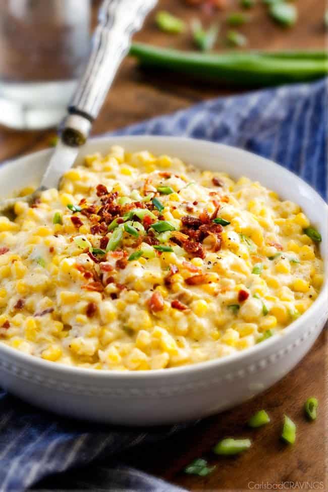 Slow Cooker Creamed Corn with Ricotta and Bacon - this has to be the BEST CREAMED CORN I've eaten in my entire life! Rich and creamy, seasoned to perfection, SO easy and practically fool proof! Definitely making this every Thanksgiving from now on! southern creamed corn in a white bowl with a silver serving spoon