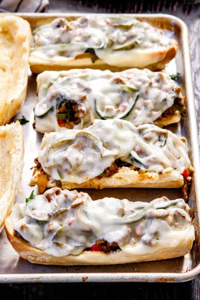 these crazy tender, flavorful Philly Cheesesteak Sandwiches are the BEST EVER! The incredible marinated steak and spiced mayo set these worlds above other recipes I've tried. You seriously haven't tried Philly Cheesesteak Sandwiches until you try these - and so much easier than you think! showing how to make easy Philly Cheesesteak sandwiches by melting cheese in the oven