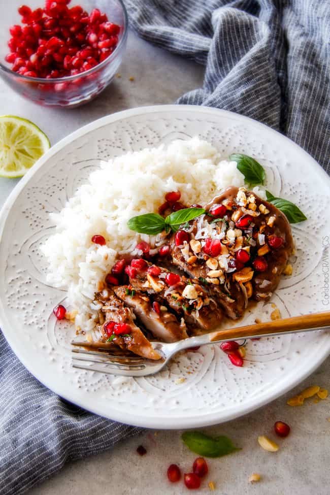 Asian Pomegranate Coconut Chicken Skillet on a white plate with rice.