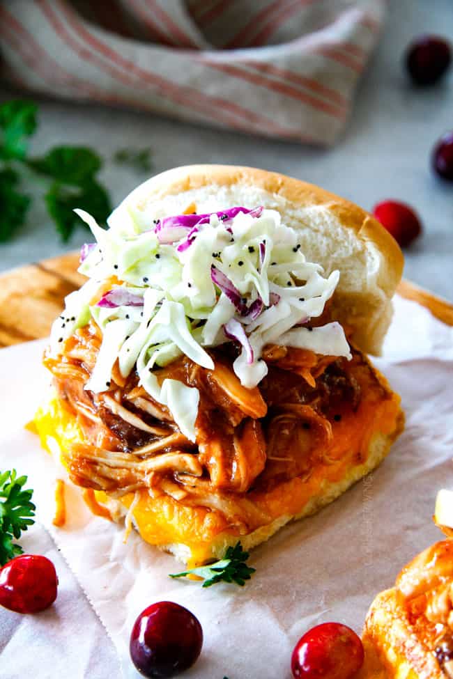 20 Minute Chipotle BBQ Cranberry Turkey Sliders (or chicken!) are a wonderfully delicious way to devour your Thanksgiving turkey leftovers or SO good you will want to make them forever and ever with chicken! And don’t skip the crunchy, sweet and tangy out of this world Apple Poppy Seed Slaw! up close of Thanksgiving pulled turkey sliders with glaze