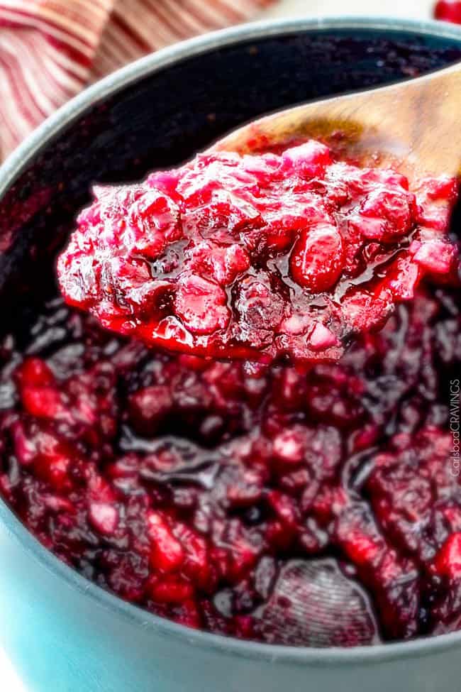 Close up of Pineapple Cranberry Sauce on a wood spoon.