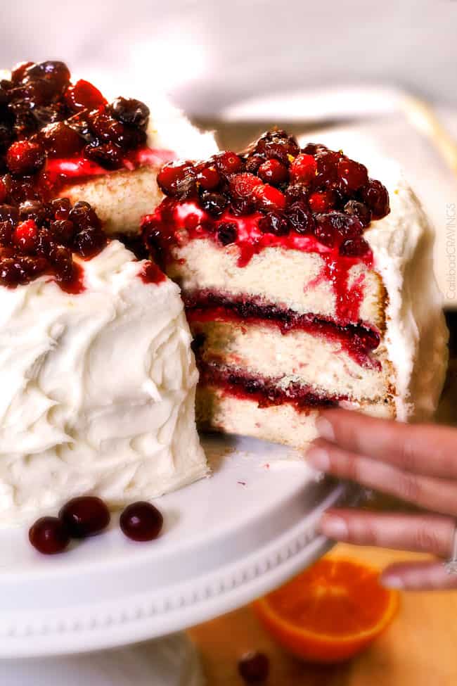 A layered cranberry cake with a slice of cake being served.