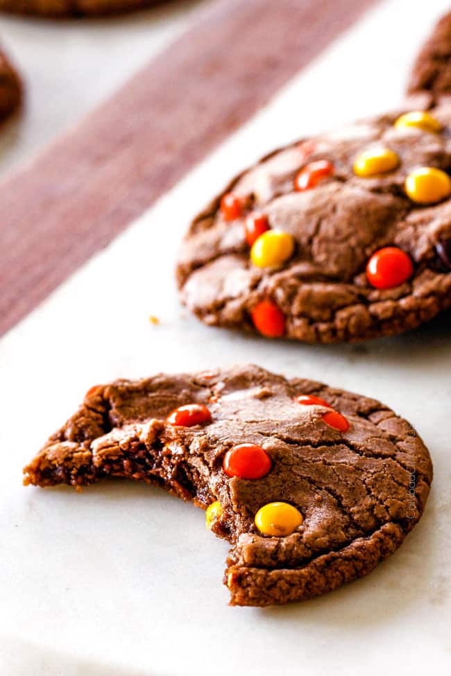 These Super soft and chewy Nutella Cookies are my absolute favorite chocolate cookie with a whole cup of Nutella mixed right into the batter! Mix in anything you want from chocolate chips to, Reese's pieces to Andes mints for the perfect Christmas cookie! up close of a chewy nutella cookie with a bite taken out of it