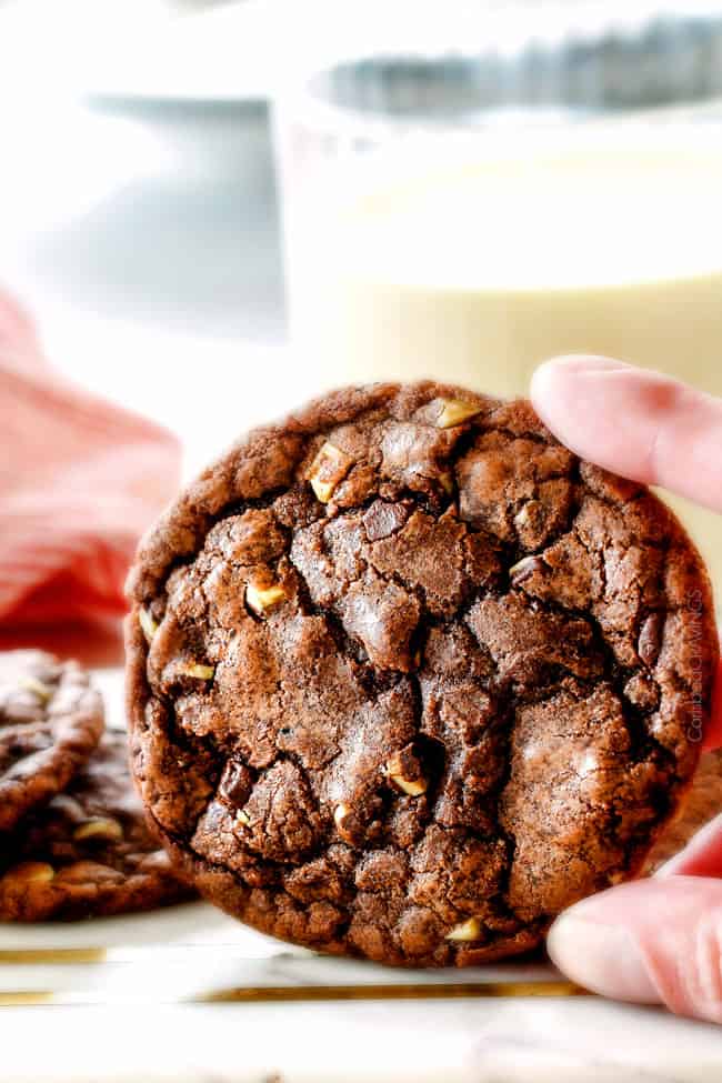 These Super soft and chewy Nutella Cookies are my absolute favorite chocolate cookie with a whole cup of Nutella mixed right into the batter! Mix in anything you want from chocolate chips to, Reese's pieces to Andes mints for the perfect Christmas cookie! up close of holding easy nutella cookies with andes mints