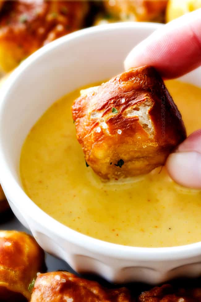 dipping a piece of monkey bread recipe in honey mustard sauce