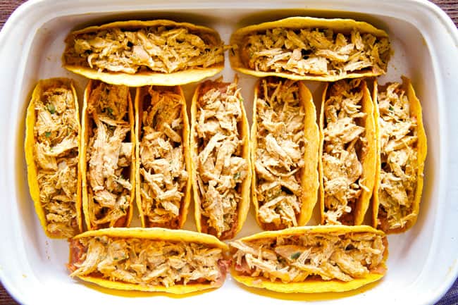 Showing how to make Ranch Chicken Tacos piled by adding chicken to the taco shells.
