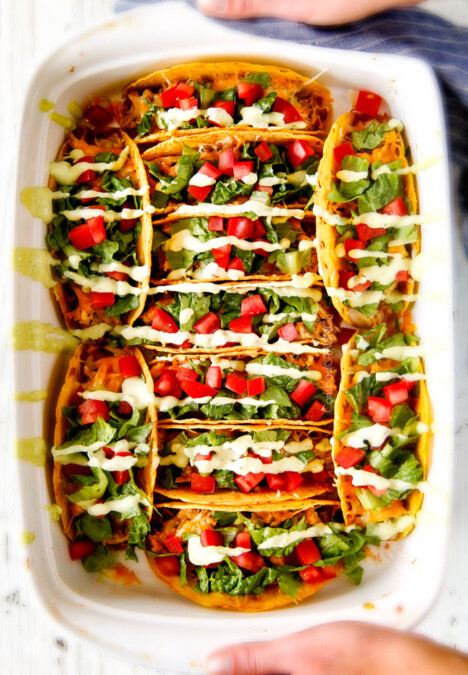 EASY Baked Fiesta Ranch Chicken Tacos piled with refried beans, cheese and the most amazing slow cooker chicken making assembly a snap! My family begs for these tacos weekly! And don't skip the Tomatillo Avocado Ranch - its to die for!