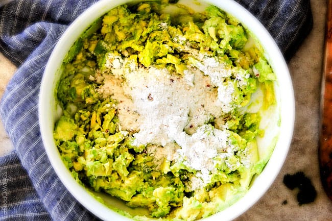 This creamy Avocado Hummus is SO addicting and only 3 ingredients! Its crazy flavorful, healthy and super easy! showing how to make avocado hummus by adding seasonings to avocados