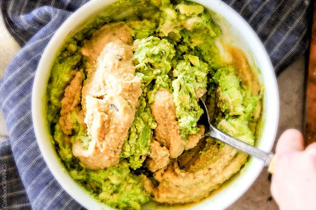 This creamy Avocado Hummus is SO addicting and only 3 ingredients! Its crazy flavorful, healthy and super easy! showing how to make avocado hummus by stirring in hummus