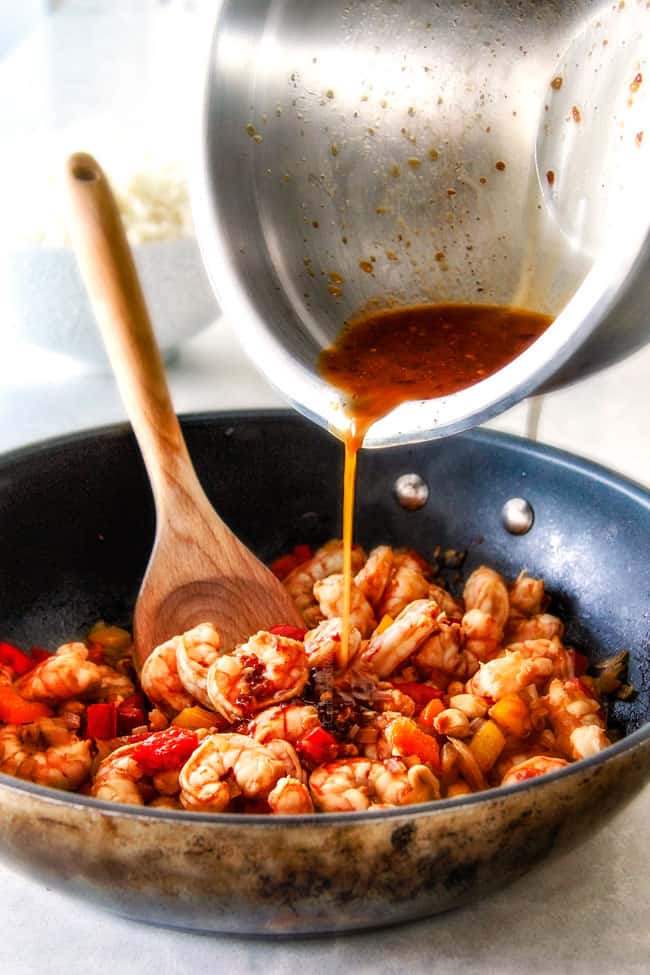 This easy, healthy, Kung Pao Shrimp tastes better than takeout and is on your table in less than 30 minutes! I was licking my plate of the savory spicy sauce! showing how to make Kung Pao Shrimp by adding Kung Pao Sauce to a skillet with shrimp