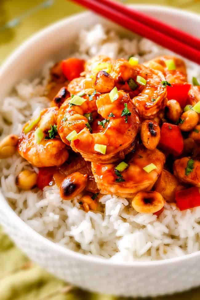 This easy, healthy, Kung Pao Shrimp tastes better than takeout and is on your table in less than 30 minutes! I was licking my plate of the savory spicy sauce! side view of healthy Kung Pao Shrimp with peanuts and bell peppers over rice