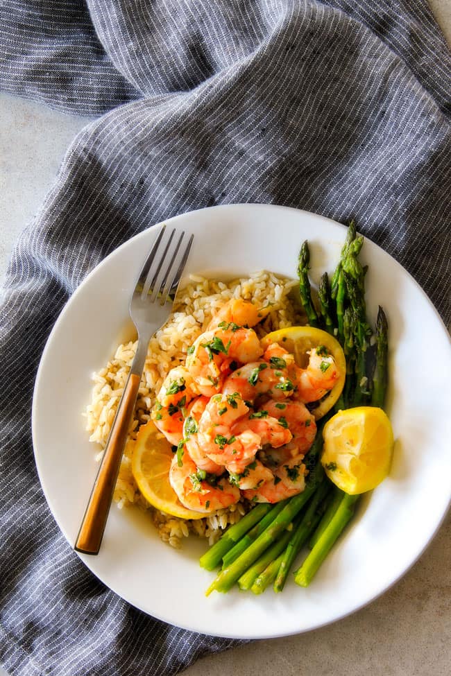 A plate with rice of Roasted Lemon Garlic Butter Shrimp and Asparagus.
