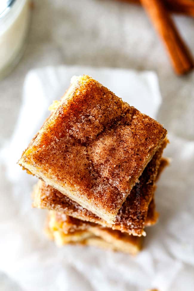 Incredibly EASY, thick, soft and chewy, buttery Snickerdoodle Cookie Bars taste just like the cookie but so much easier and less time consuming! The cinnamon and sugar crackle top is to die for! top view of best snickerdoodle bars coated in cinnamon and sugar