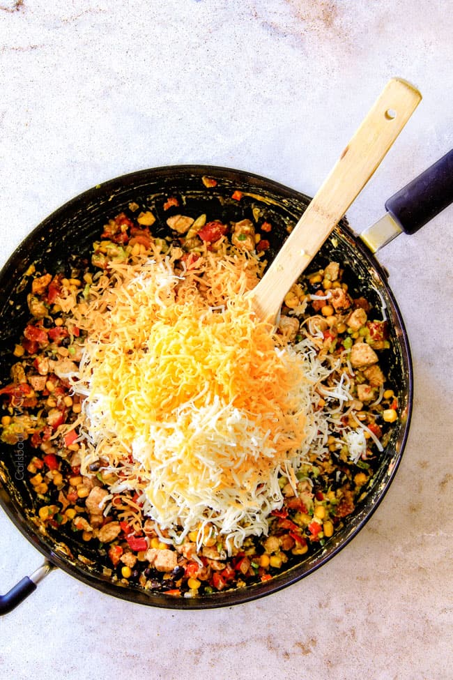 CRISPY Southwest Egg Rolls loaded with Mexican spiced chicken, beans, tomatoes, rice, avocado and cheese! These egg rolls are unreal! So much flavor and texture! And don't skip the Cilantro Lime Ranch Dip - its heaven! Showing how to make easy Southwest Egg Rolls by by adding shredded cheese tot filling