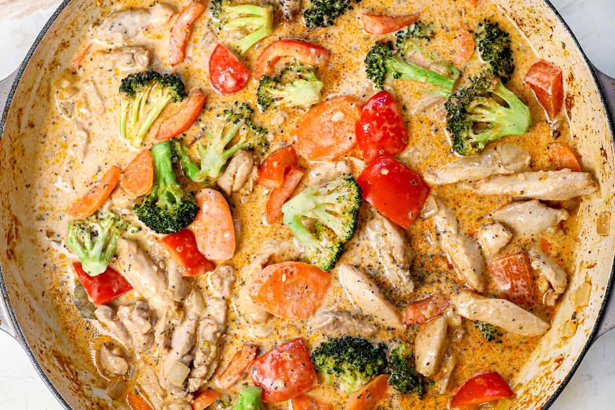 showing how to make chicken curry by simmering until the sauce thickens and the vegetables reach desired crisp-tenderness.