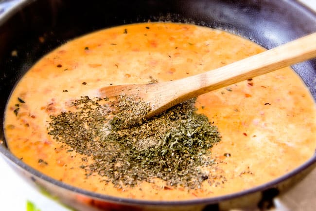 Showing how to make Garlic Mozzarella Margherita Pasta adding spices to the sauce.