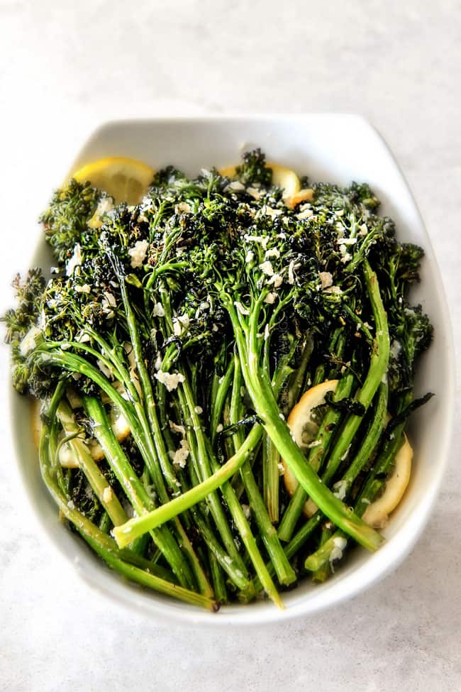 Roasted Parmesan Lemon Garlic Broccoli on a plate with lemon in a serving bowl.