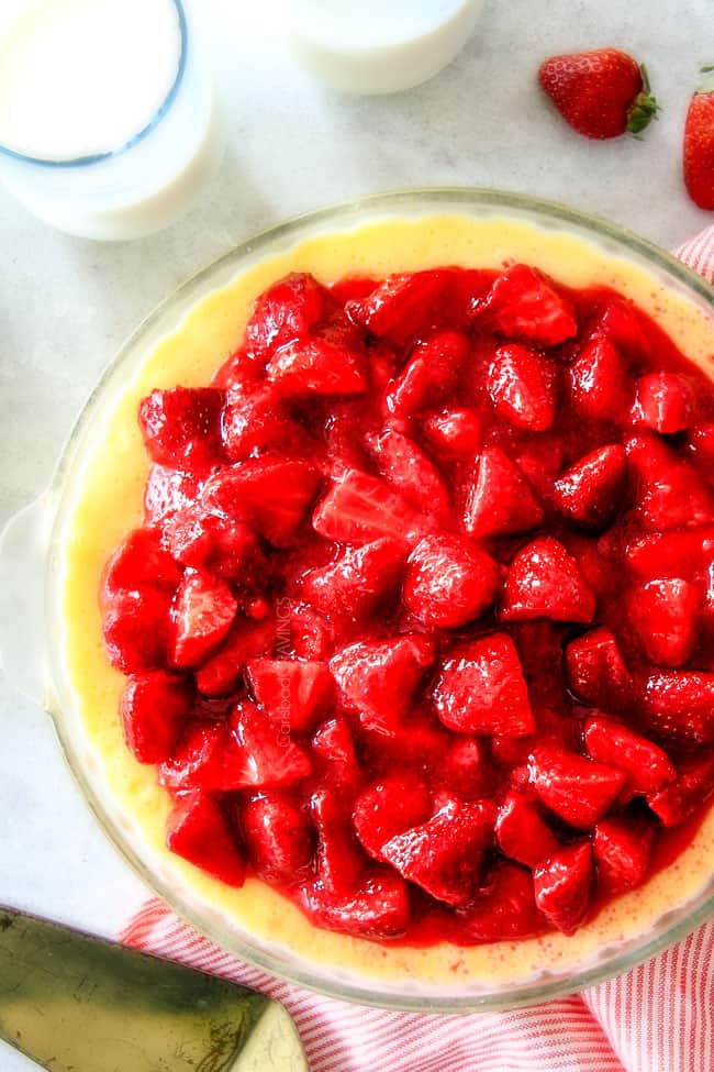 A full Strawberry Cheesecake with milk glass.