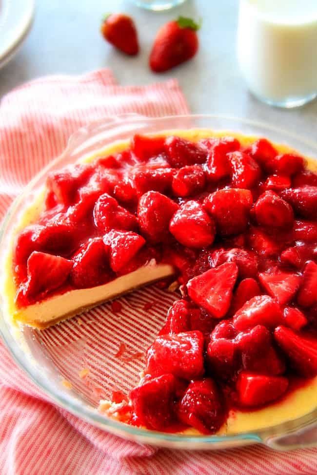 Strawberry Cheesecake in a glass pan with a piece missing.