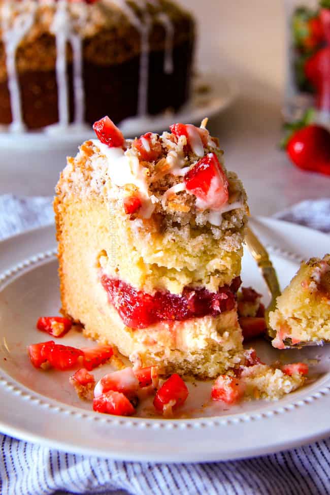 Strawberry Cream Cheese STUFFED Sour Cream Coffee Cake - this is the best strawberry coffee cake ever! the INCREDIBLY creamy cheesecake-like cream cheese filling and strawberries all topped with Coconut Pecan Streusel and Lemon Drizzle is OUT OF THIS WORLD! I can't say enough good things about this coffee cake! half eaten slice of easy Cream Cheese Coffee Cake