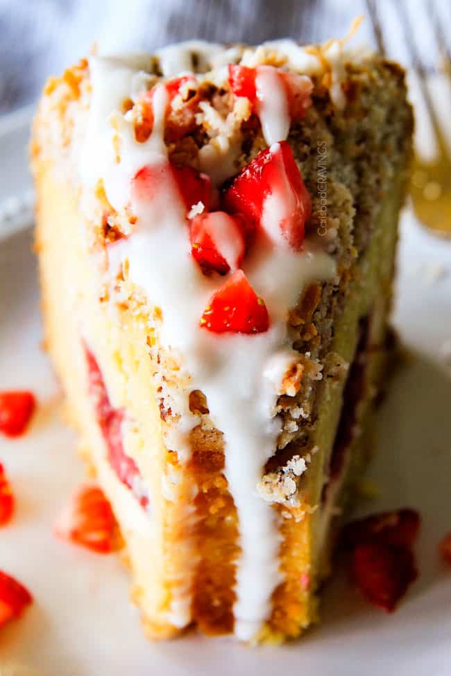 Strawberry Cream Cheese STUFFED Sour Cream Coffee Cake - this is the best strawberry coffee cake ever! the INCREDIBLY creamy cheesecake-like cream cheese filling and strawberries all topped with Coconut Pecan Streusel and Lemon Drizzle is OUT OF THIS WORLD! I can't say enough good things about this coffee cake! up close of a slice of the best Cream Cheese Coffee Cake recipe