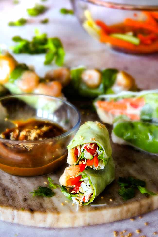 These insanely delicious Fresh Shrimp Spring Rolls are a flavor and texture explosion in every addictive bite and super easy to make with all my tips and tricks and step by step photos! and the the Pineapple Hoisin Peanut Sauce is EVERYTHING! Vietnamese Spring Rolls with peanut sauce on a marble cutting board