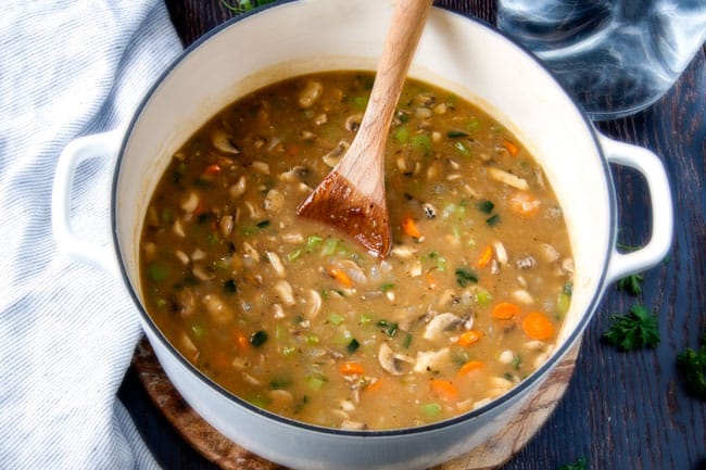 Philly Cheesesteak Soup mixing with a wood spoon.