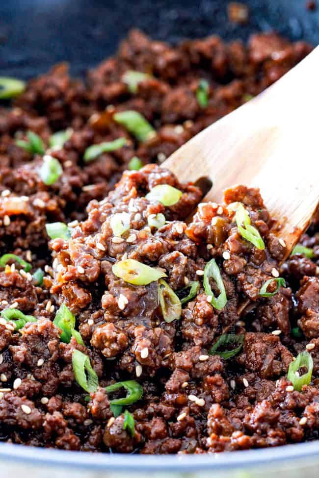 showing how to make Korean beef bowl by stirring sauce into beef in a skillet