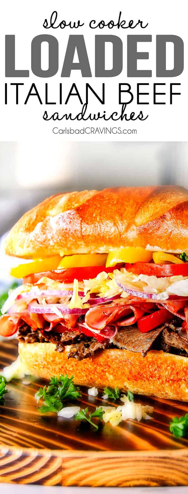 Easy, customizable LOADED Slow Cooker Italian Beef Sandwiches are crazy tender, seeping with flavor and unbelievably delicious! They make the easiest dinner or party food and super fun (make ahead!) sandwich bar! quick italian beef sandwich recipe with a fully loaded Italian beef sandwich on a cutting board