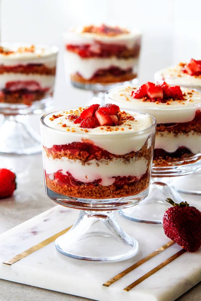 Strawberry Cheesecake Parfaits with strawberries on the side.