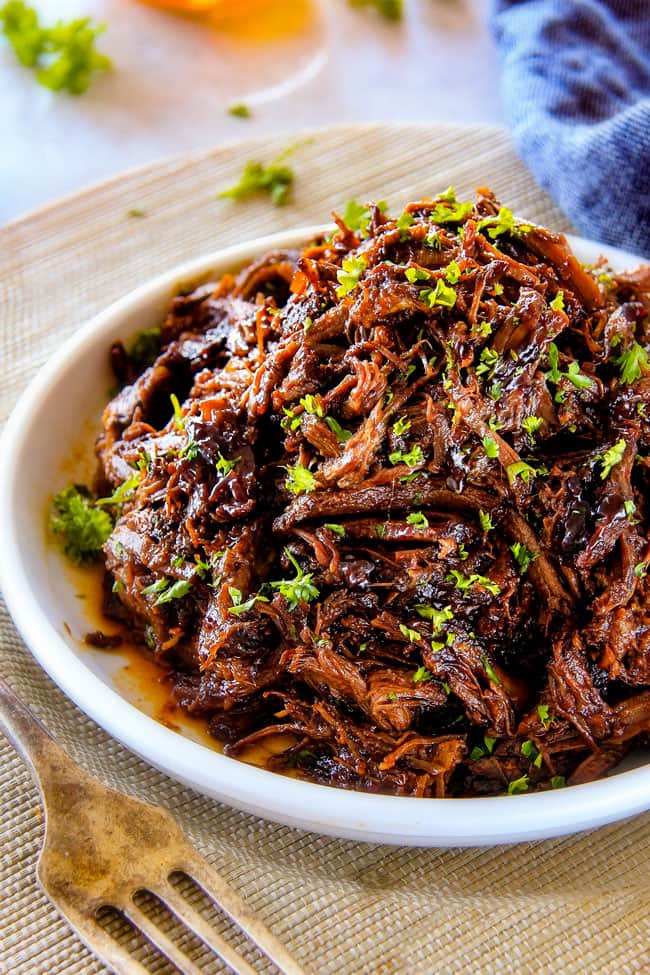 I am obsessed with this sweet and tangy, savory Slow Cooker Honey Balsamic Beef!!! It's fall apart tender, crazy juicy, packed with flavor and smothered in the most AMAZING honey balsamic sauce! perfect for sandwiches or stand alone delicious with rice and potatoes! best Slow Cooker Roast Beef on a white plate
