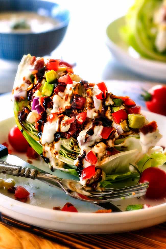 Outback Copycat Wedge Salad smothered in the most amazing creamy, decadent Blue Cheese Ranch and Balsamic Reduction is a flavor/texture lovers dream and crazy easy to make! side view of easy Wedge Salad topped with blue cheese dressing
